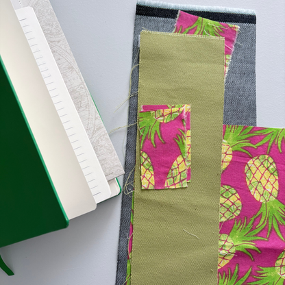 Fabric swatches with pineapple pattern  and notebook on a white background