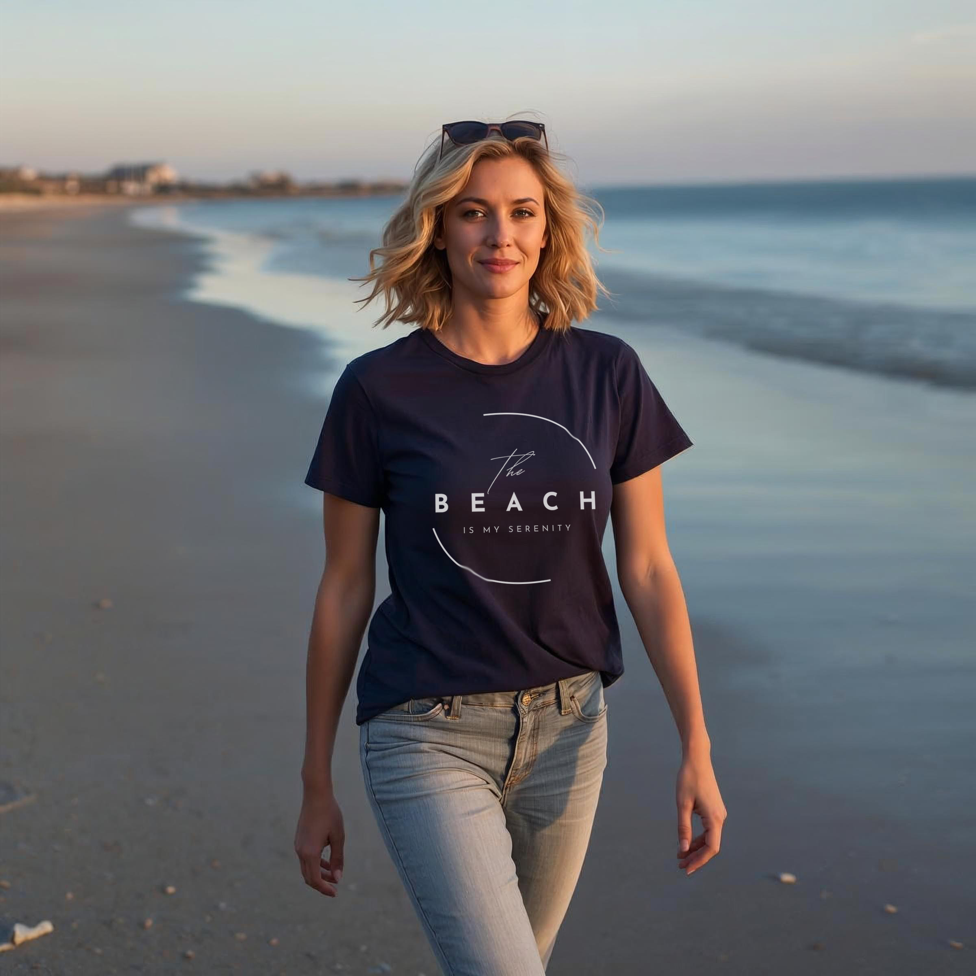 Woman wearing a t-shirt with 'The Beach is my Serenity' walking on a beach in the early summer evening