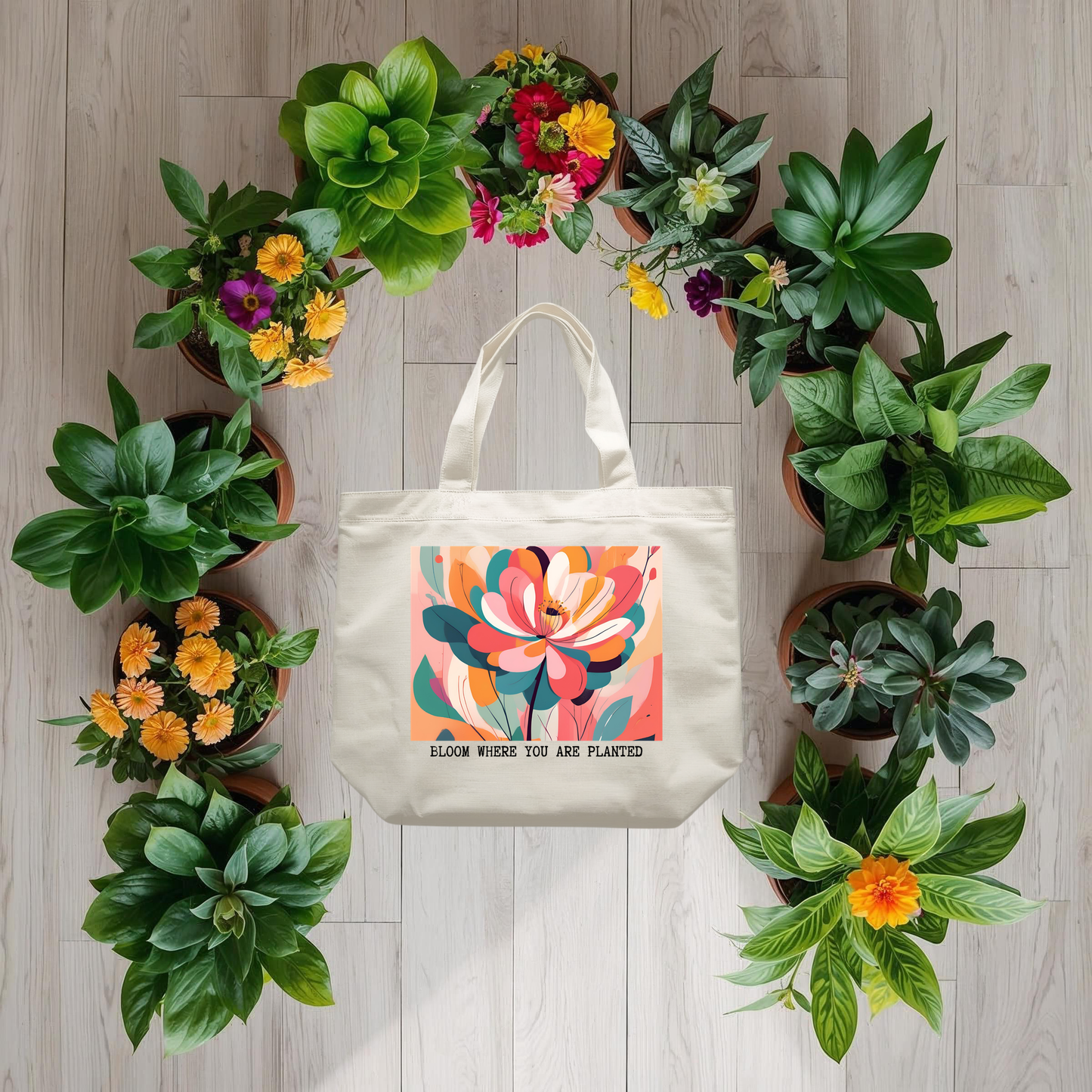 Tote bag with floral design and "bloom where you are planted" text surrounded by potted plants on a wooden floor