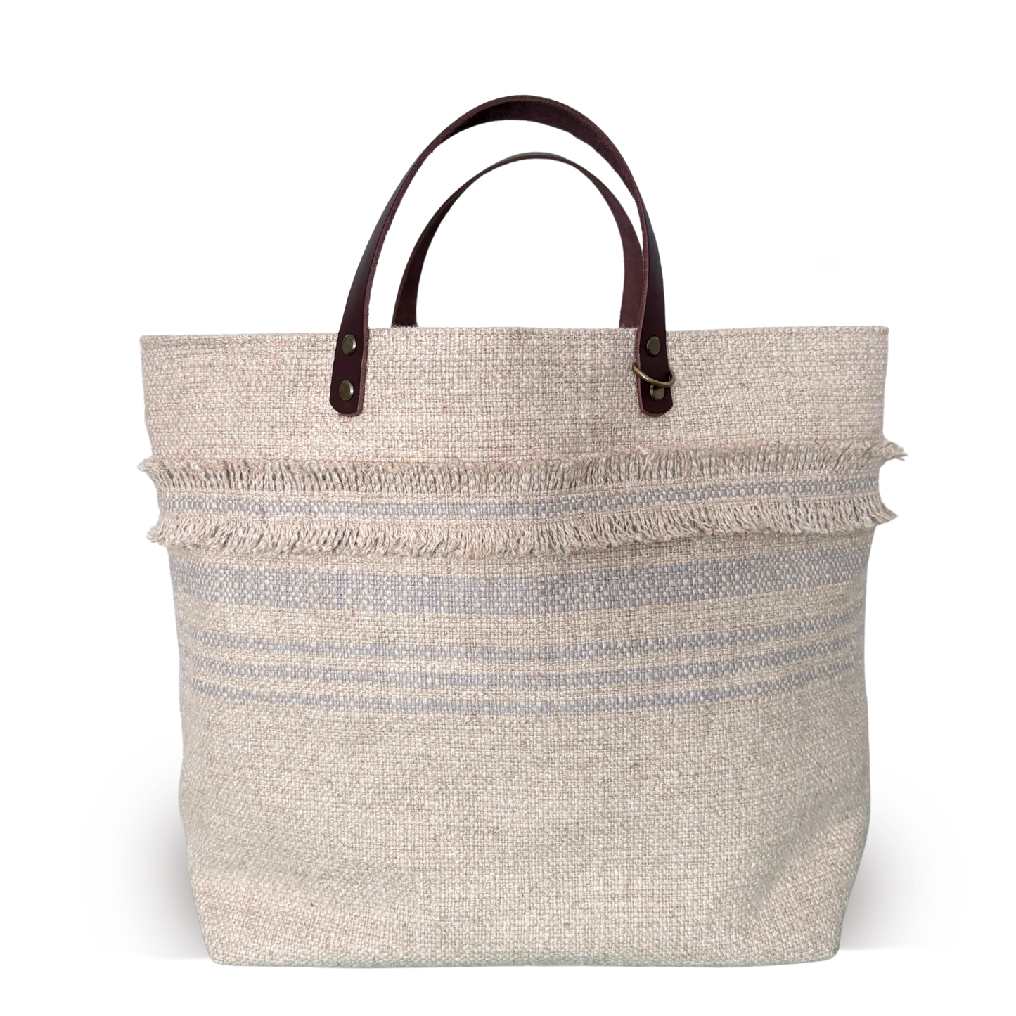 Beige woven tote bag with brown leather handles on a white background