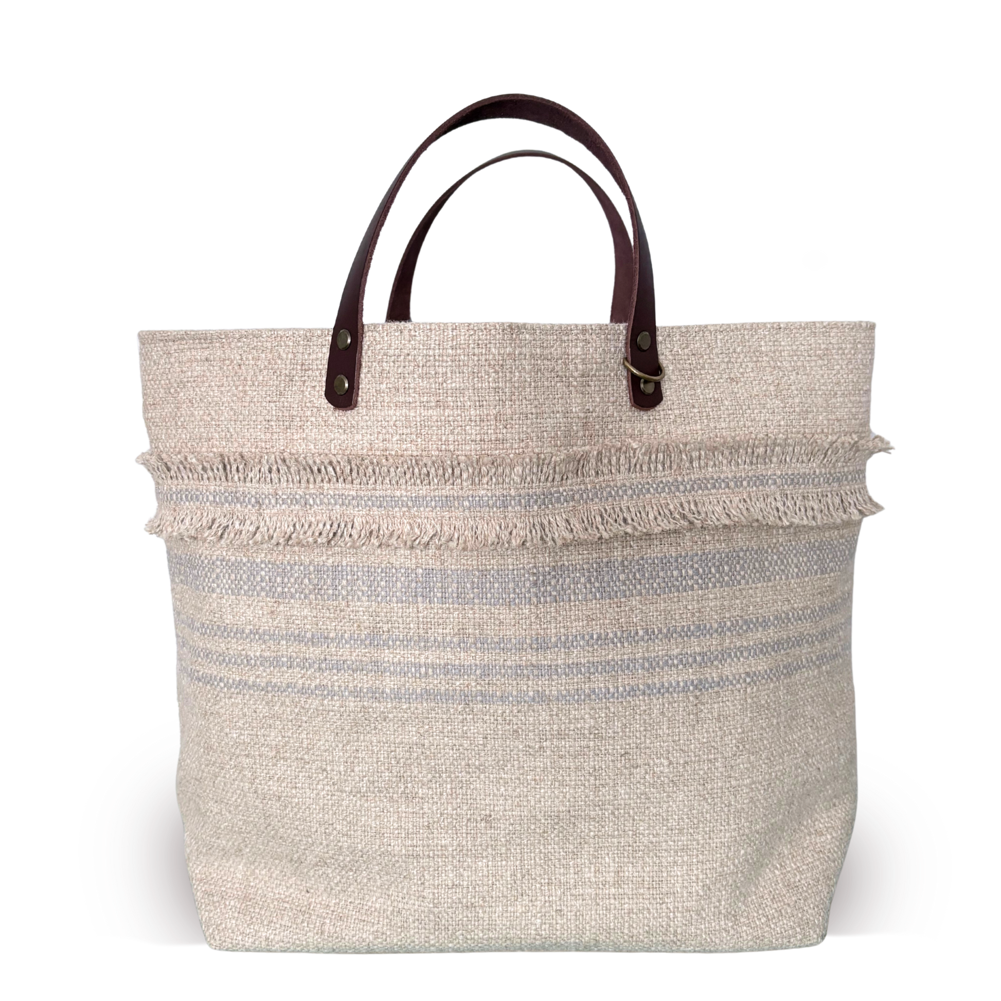 Beige woven tote bag with brown leather handles on a white background