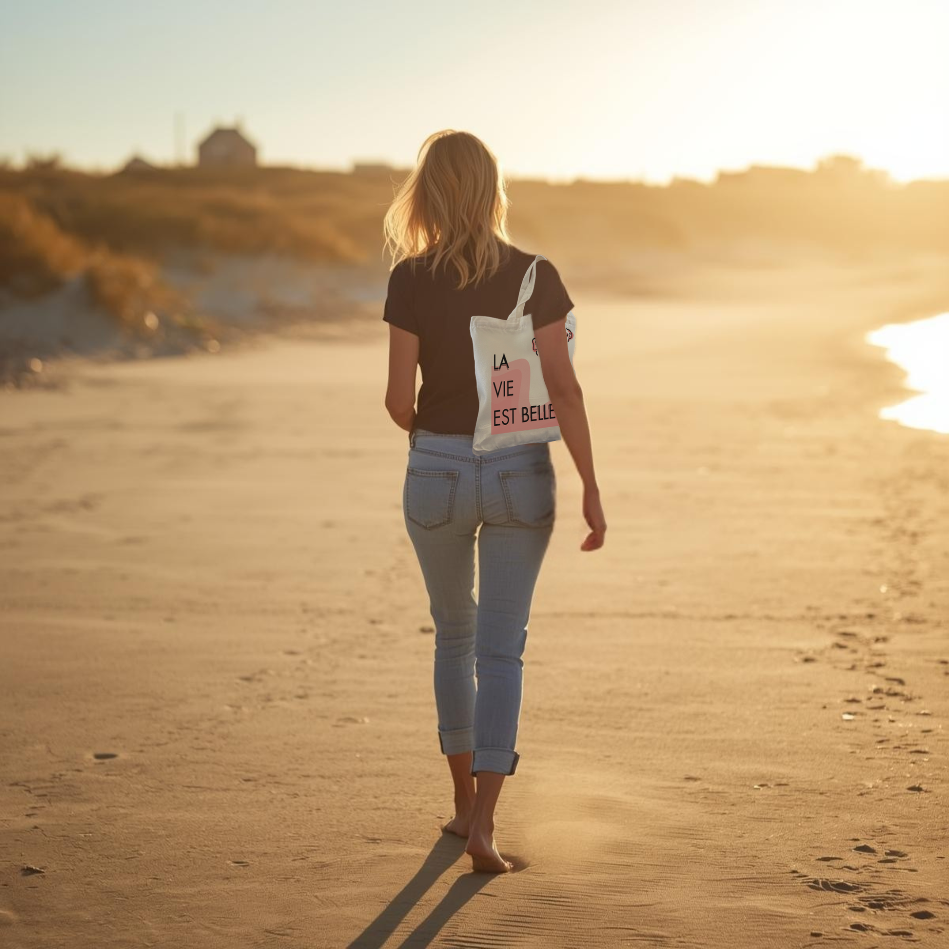 Woman walking on a beach with a quote bag at sunset